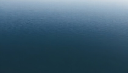 Obraz premium A serene view of calm water with gentle ripples, reflecting a soft blue hue. The surface appears smooth and tranquil, creating a peaceful atmosphere.