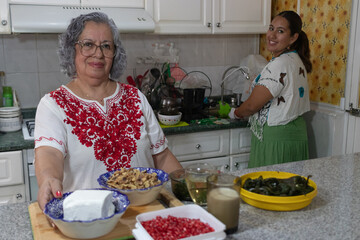 Traditional Mexican cooks showing the ingredients to prepare the traditional Mexican chiles en...
