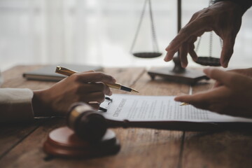 Business and lawyers discussing contract papers with brass scale on desk in office. Law, legal services, advice, justice and law concept picture with film grain effect