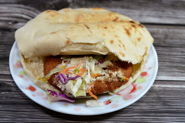 Stuffed Falafel sandwich, a very popular and traditional Egyptian food, a Shami Syrian pita bread stuffed with crispy hot falafel balls with cool and crunchy diced tomatoes, cucumbers, onions, tahini