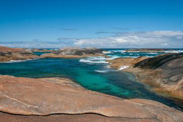 Elephant Rocks in Western Australia, where massive granite boulders meet crystal-clear turquoise waters, creating a serene coastal landscape under a bright blue sky. A stunning natural attraction.
