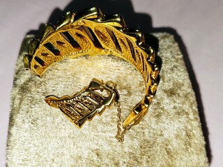 Broken gold bracelet, Jewellery or jewelry, decorative items worn for personal adornment, an article of jewellery that is worn around the wrist, Decrease gold price concept, inflation and economy