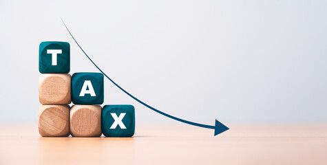 TAX wording on wooden cube block with down arrow  for Vat reducing concept.