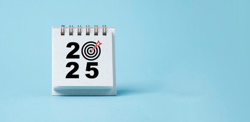 2025 with dartboard arrow on blue calendar for setup business setup objective  target and goal when...