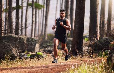 Running, man and serious with fitness in forest for healthy body, cardio or exercise in morning....