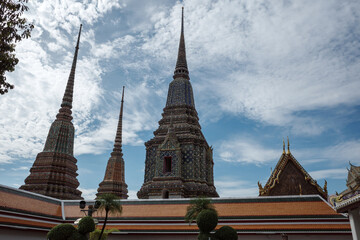 Fototapeta premium A stunning view of the iconic spires (chedis) at Wat Pho, a renowned Buddhist temple complex in Bangkok, Thailand. 