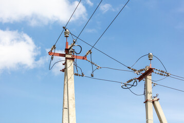 A pole with electric wires against a blue sky