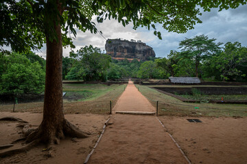 SIGIRIYA, SRI LANKA - JULY 15, 2024 : A view looking through the Royal Garden towards Sigiriya Rock Fortress in central Sri Lanka.