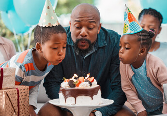 Man, blowing candles and birthday cake with children for celebration, gathering and event in home...