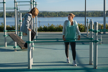 child and mother doing exercises together at city sports ground