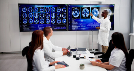 Doctors In Clinic Looking At Brain MRI Scan