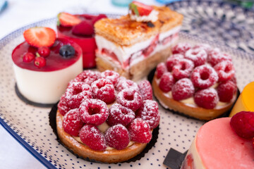 assortment of desserts and cakes with summer fruits and berries