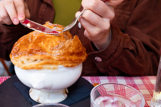 onion soup served with baked french pastry on top surved in a restaurant in france