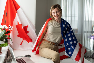 Positive teacher in headset having online lesson on laptop near globe and flags in school