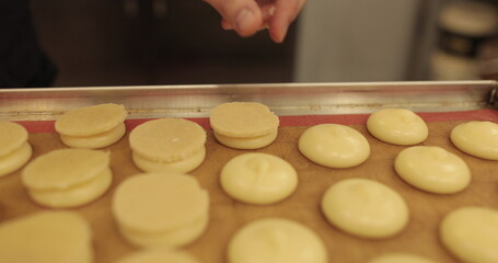 Making macarons. The process of making a French dessert. Pasta macaroni. Food industry, serial or mass production. 4K video recording.