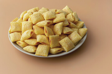 Cookies - corn cushions with strawberry flavored filling on a plate on an orange background