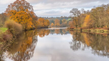 Obraz premium Serene river landscape with fall colors, calm water reflection and peaceful autumn scenery.