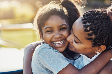 Mom, hug and kiss happy kid at park for love, support and care with family. African mother, child and embrace girl at playground for connection, adoption and laughing with parent on holiday outdoor