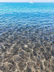 Sandy seabed of the shore clearly visible due to the excellent clarity of the water. Favignana island, Aegadian islands, Sicily, Italy.