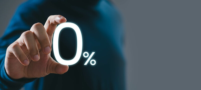 A person in a dark shirt touches a glowing 0% sign, representing zero percent, offers, discounts, promotions, or interest rates on a gray background.