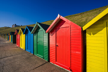 Colourful beach huts line the promenade in Whitby