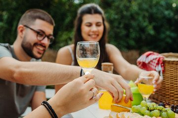 Group of three friends or family having picnic in backyard or garden