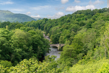 High angle view over the River Dee with the Pontcysyllte Old Bridge between green tree covered hills near Llangollen, UK