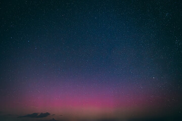 A breathtaking night sky filled with stars, highlighted by a faint aurora borealis in shades of...