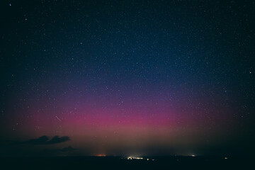 A breathtaking night sky filled with stars, highlighted by a faint aurora borealis in shades of...