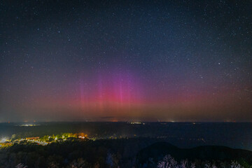 A breathtaking night sky filled with stars, highlighted by a faint aurora borealis in shades of...