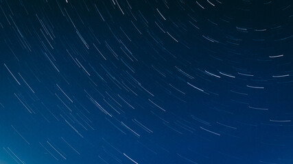 A mesmerizing long-exposure shot captures star trails swirling across the night sky above a...