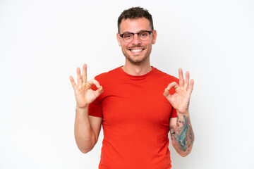 Fototapeta premium Young caucasian handsome man isolated on white background showing ok sign with two hands