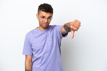 Young caucasian Brazilian man isolated on white background showing thumb down with negative...