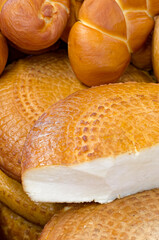 Assorted traditional homemade smoked cheeses on a market stall