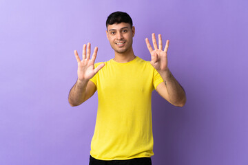 Young Colombian man isolated on purple background counting nine with fingers