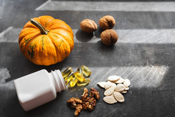 Yellow capsules of omega 3, fatty acid supplement pills with pumpkin seeds and walnuts