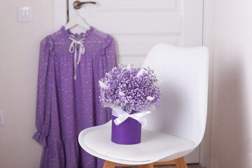 
Bouquet of beautiful violet flowers and dress on apartment background