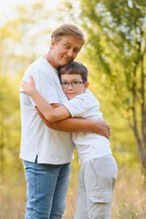 Fototapeta premium Grandmother walking with her grandson. Relaxing and joying in sunset