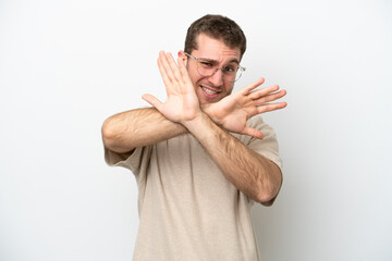 Young caucasian man isolated on white background nervous stretching hands to the front