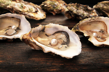 Concept, women's happiness and men's health. Fresh sea oysters on a dark wooden background. Open...