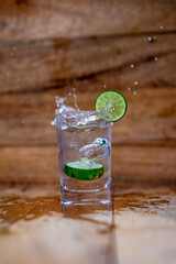 Water splash from green orange drink glass