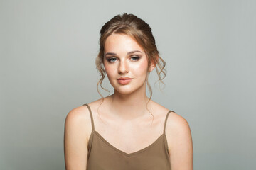 Beauty fashion portrait of elegance woman with fresh skin, updo hair and makeup on white...