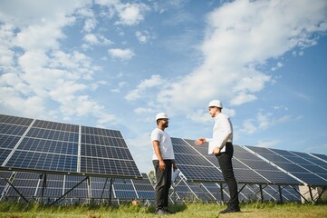 The solar farm, solar panel with two engineers walk to check the operation of the system, Alternative energy to conserve the world's energy
