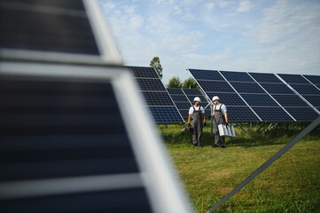 Engineering team working on checking and maintenance in solar power plant, Solar panel technician installing solar panels a sunny day