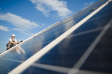 Worker installing solar panels outdoors © Serhii