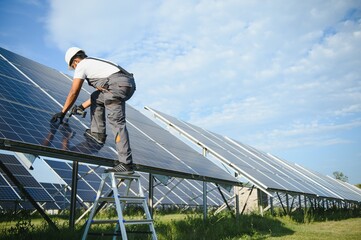 Portrait of handsome Indian worker near solar panels