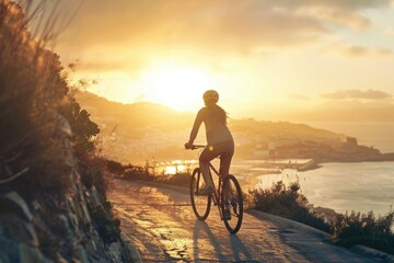 Fototapeta premium A woman rides her bicycle along the side of a body of water, with the sun shining down on them