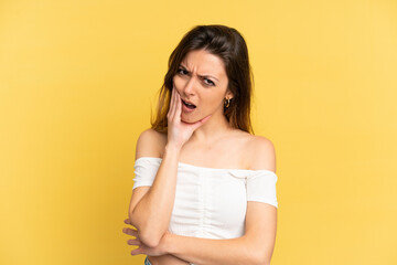 Young caucasian woman isolated on yellow background with toothache