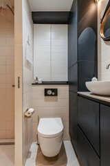A photo of the modern bathroom in an apartment, white walls with light gray tiles on floor and wall, one black cabinet under sink, toilet is integrated into flooring, 