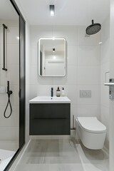 A photo of the modern bathroom in an apartment, white walls with light gray tiles on floor and wall, one black cabinet under sink, toilet is integrated into flooring, 